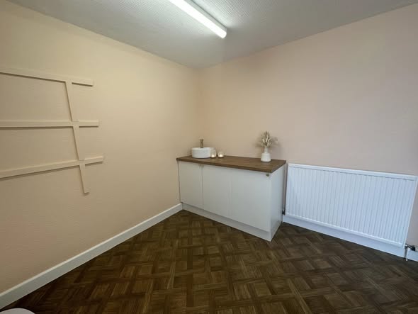 Room with decorative wall panelling and a white cabinet