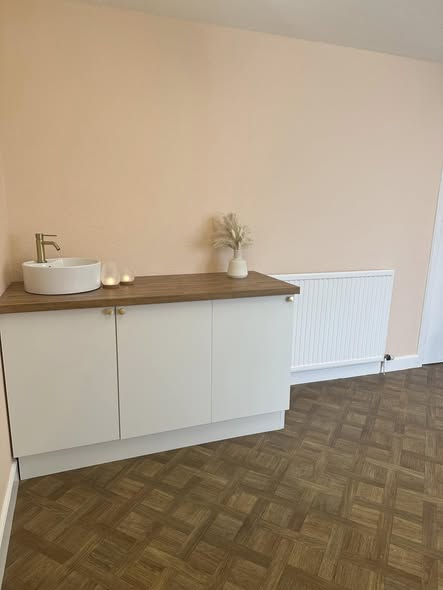 Sink and white cabinet with a wooden worktop at The Coach House